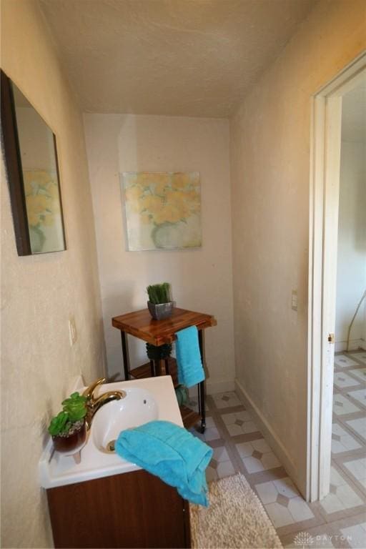 bathroom featuring vanity, baseboards, and tile patterned floors