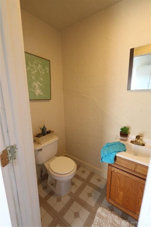 bathroom with tile patterned floors, vanity, toilet, and baseboards