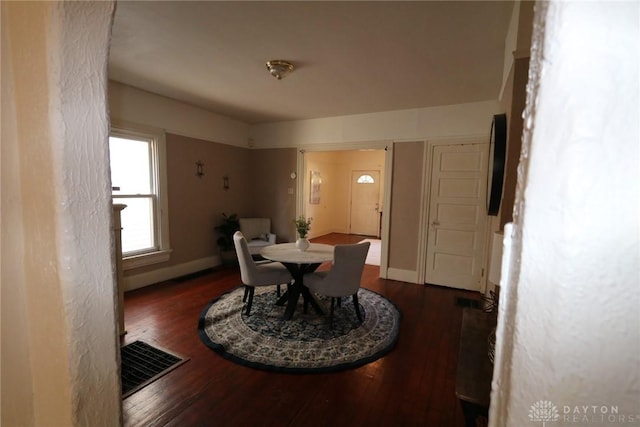 dining room featuring visible vents, baseboards, and wood finished floors