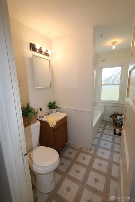 bathroom featuring a bathing tub, vanity, toilet, and tile patterned floors