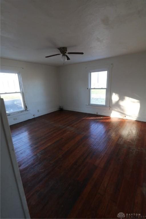 unfurnished room with dark wood-style floors, plenty of natural light, and a ceiling fan