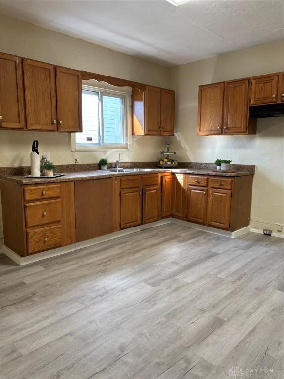 kitchen featuring light wood-style floors and brown cabinetry