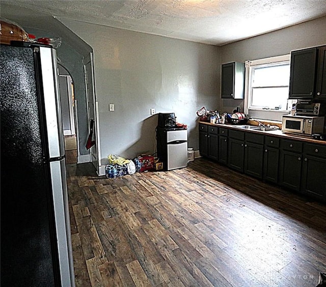 2318 Home Ave Unit 2316, Dayton, OH 45417 - kitchen featuring freestanding refrigerator, dark wood finished floors, dark cabinetry, and a textured ceiling