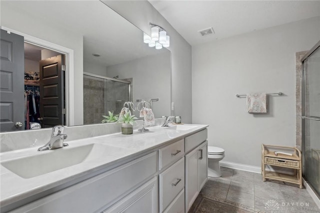 bathroom featuring vanity, a shower with shower door, and toilet