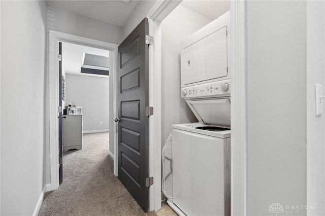 clothes washing area with stacked washer and clothes dryer and light carpet