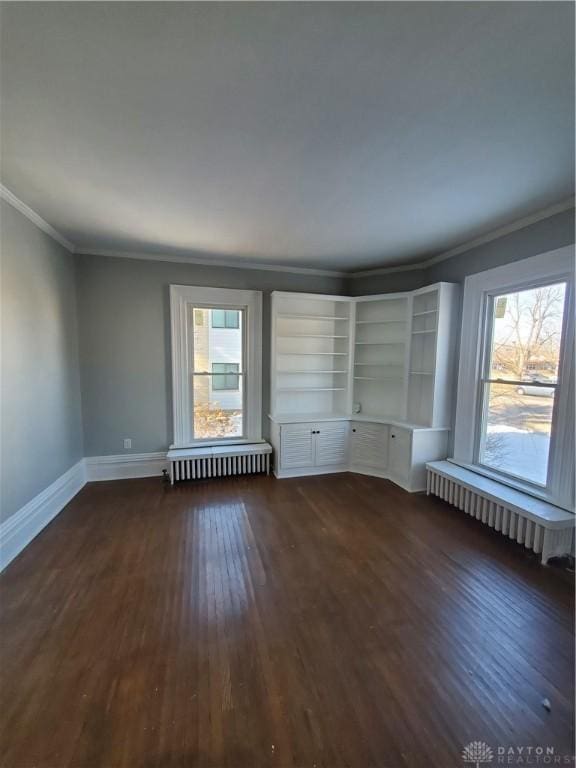 spare room with crown molding, radiator heating unit, and dark hardwood / wood-style flooring