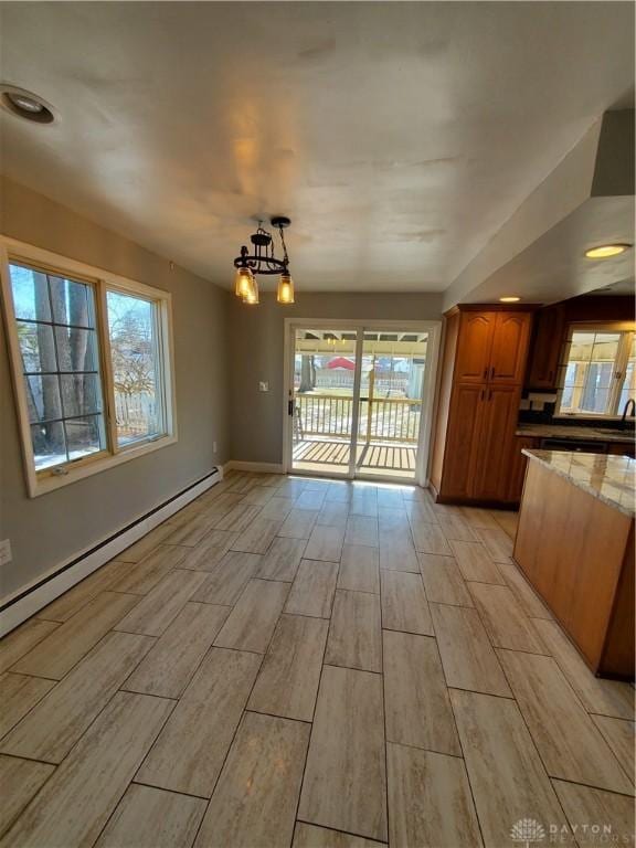 unfurnished dining area featuring sink and a baseboard heating unit