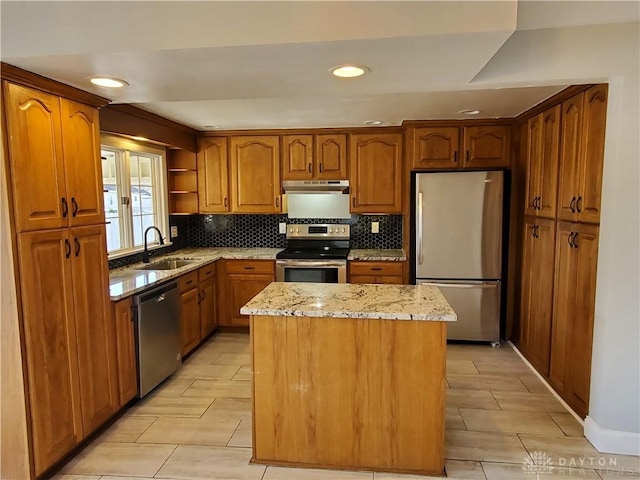 kitchen with a kitchen island, sink, backsplash, light stone counters, and stainless steel appliances