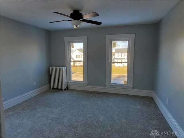 unfurnished room featuring carpet floors, radiator, and ceiling fan