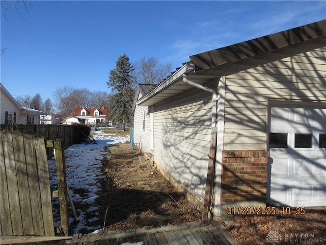 view of snowy exterior featuring a garage