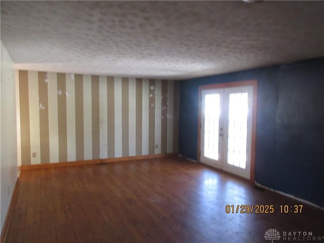 unfurnished room with hardwood / wood-style flooring, french doors, and a textured ceiling