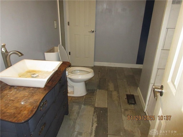 bathroom with hardwood / wood-style flooring, vanity, and toilet