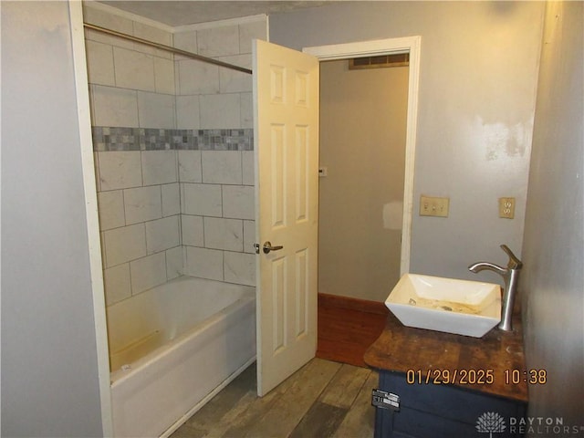 bathroom featuring hardwood / wood-style flooring, tiled shower / bath, and vanity