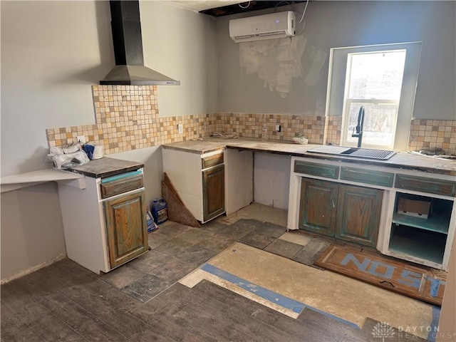 kitchen with wall chimney exhaust hood, sink, a wall mounted AC, dark hardwood / wood-style floors, and decorative backsplash