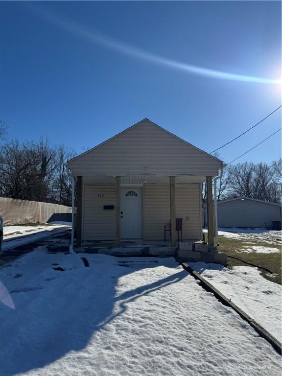 snow covered garage featuring a porch