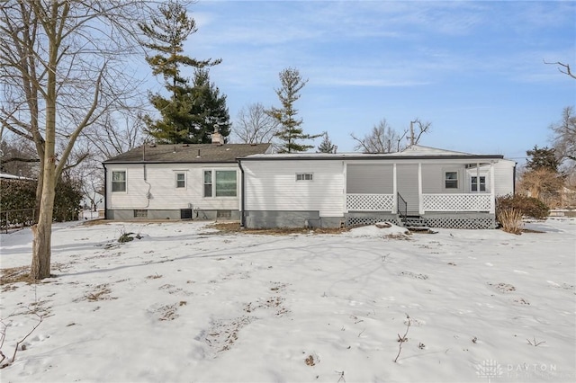 snow covered property featuring cooling unit and covered porch