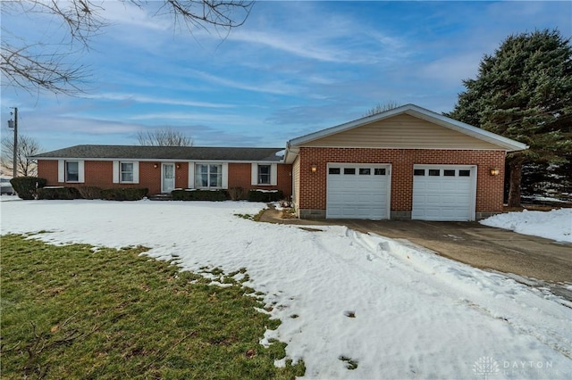 ranch-style house with driveway, brick siding, and an attached garage