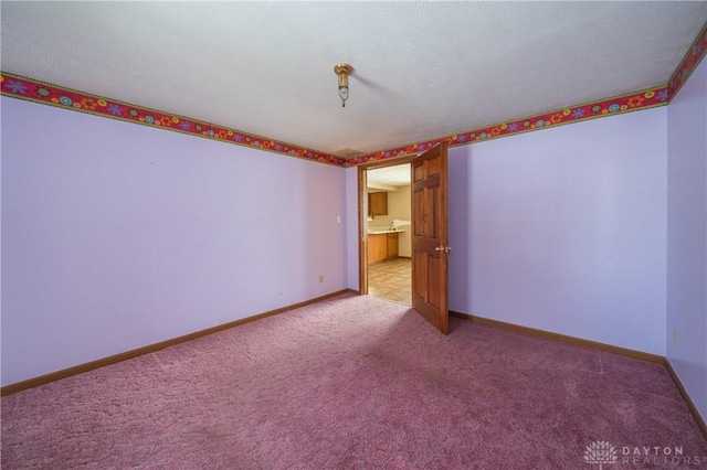 empty room featuring light carpet and baseboards