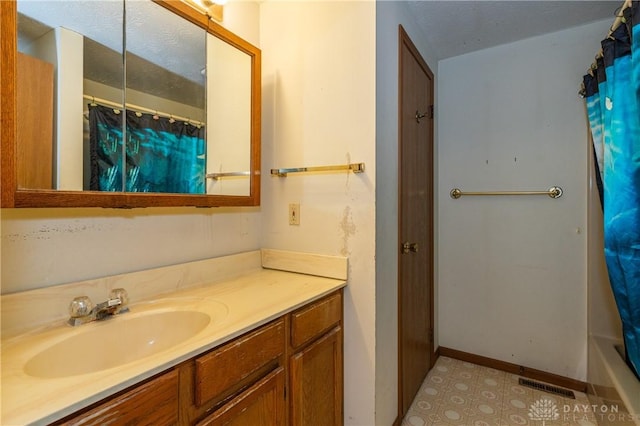 bathroom with shower / bath combo, baseboards, visible vents, a textured ceiling, and vanity