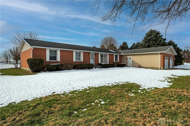 single story home with a garage, brick siding, and a lawn