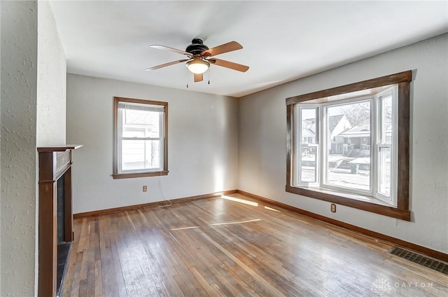 unfurnished living room with wood-type flooring, a fireplace, and ceiling fan