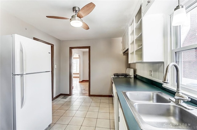 kitchen featuring light tile patterned flooring, sink, decorative light fixtures, white appliances, and white cabinets