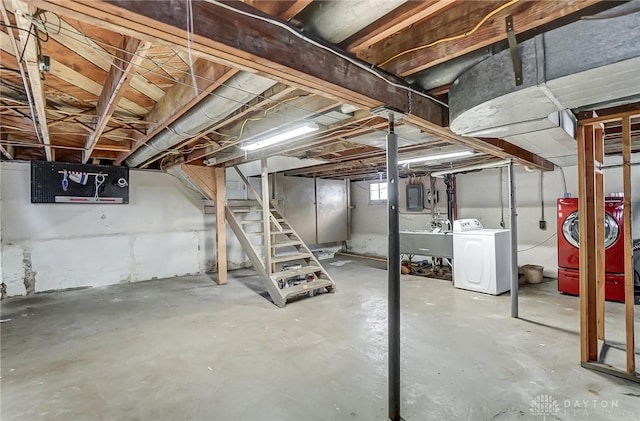 basement featuring electric panel, washer / dryer, and sink