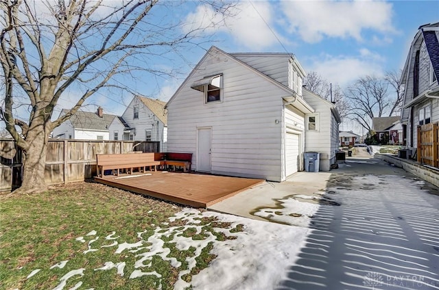 rear view of property with a garage and a deck