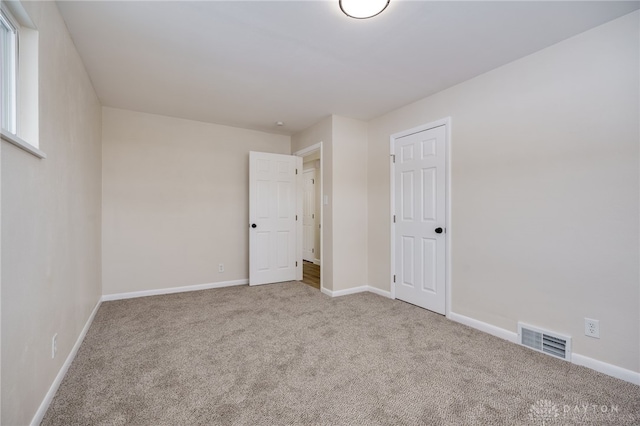 unfurnished bedroom with baseboards, visible vents, and carpet flooring