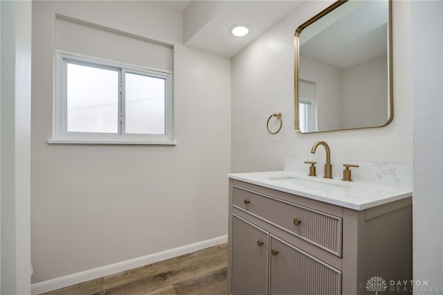 bathroom with vanity, baseboards, and wood finished floors