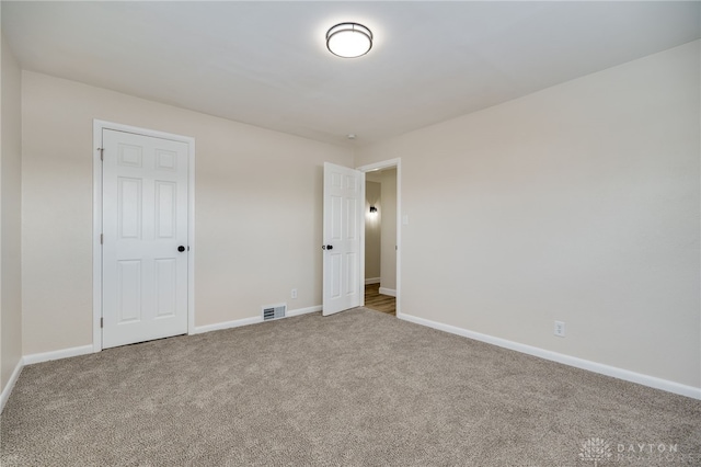 unfurnished bedroom featuring carpet, visible vents, and baseboards