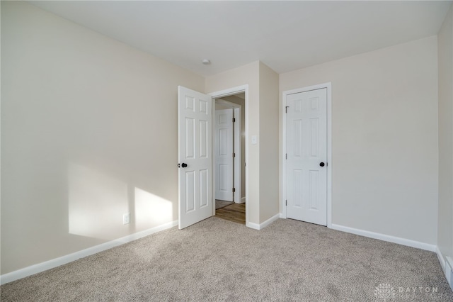 unfurnished bedroom featuring carpet flooring and baseboards