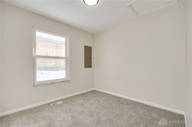 unfurnished room featuring baseboards, carpet, visible vents, and electric panel