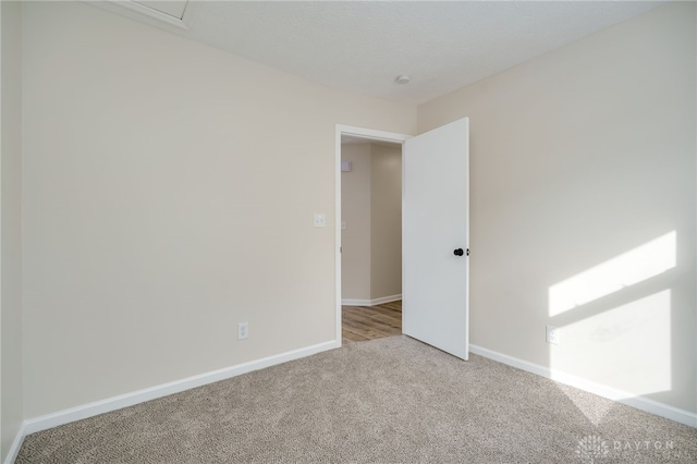 carpeted spare room featuring baseboards