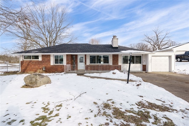 ranch-style home with brick siding, driveway, a chimney, and an attached garage