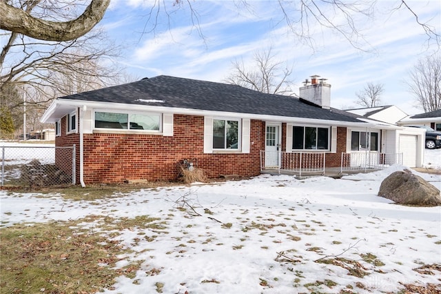 view of front of home featuring a garage, a chimney, fence, and brick siding