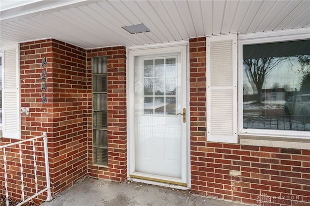 view of exterior entry featuring brick siding