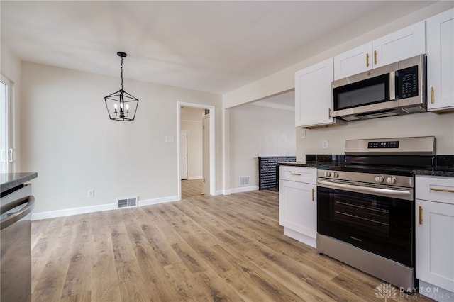 kitchen with appliances with stainless steel finishes, light wood-style floors, visible vents, and white cabinetry