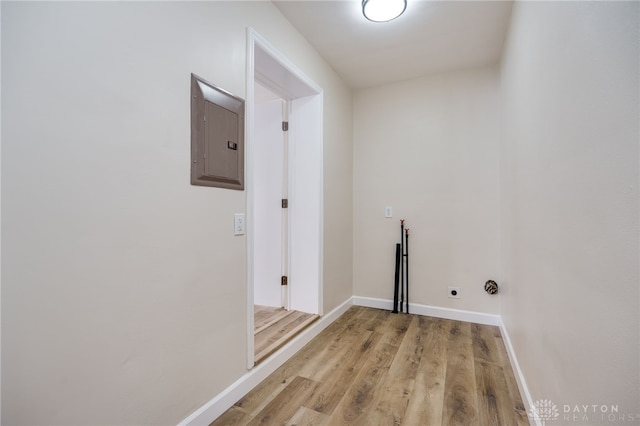 laundry area featuring hookup for an electric dryer, laundry area, baseboards, light wood-type flooring, and electric panel