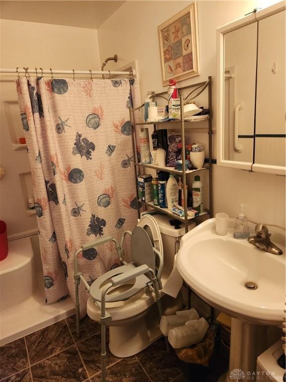 bathroom featuring shower / bathtub combination with curtain and sink