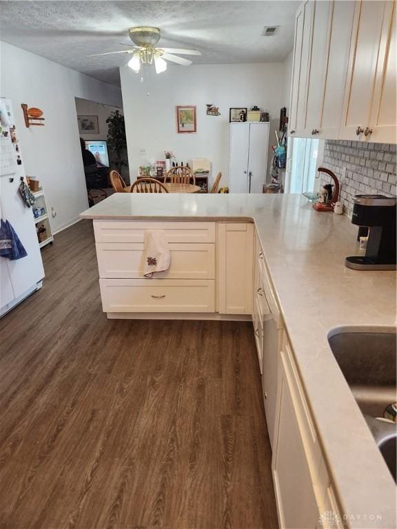 kitchen featuring white cabinetry, kitchen peninsula, dark wood-type flooring, and white fridge