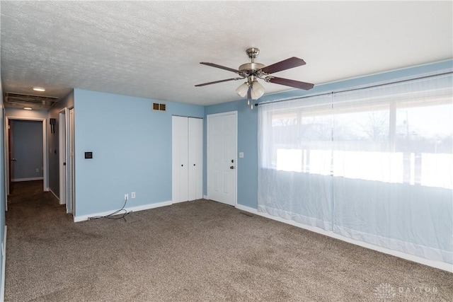 carpeted spare room with ceiling fan and a textured ceiling