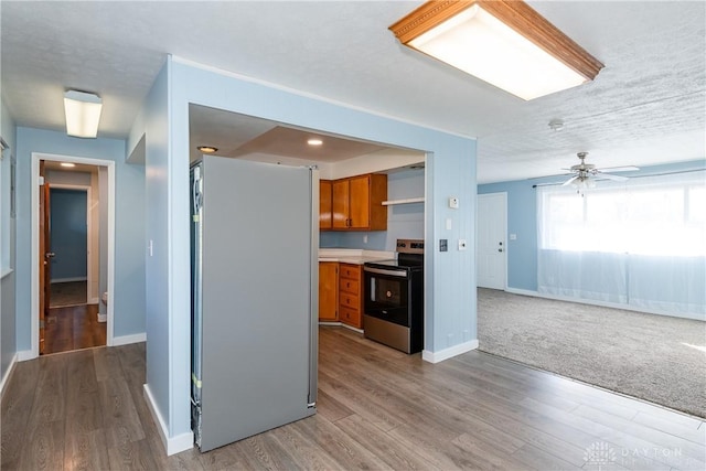 kitchen featuring appliances with stainless steel finishes, hardwood / wood-style floors, a textured ceiling, and ceiling fan