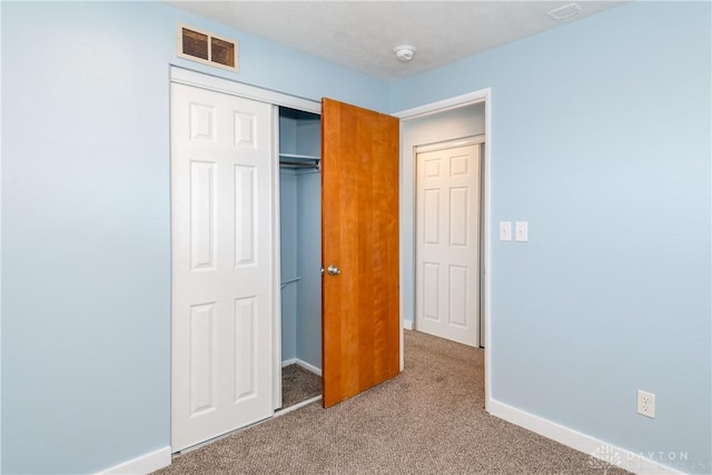 unfurnished bedroom featuring carpet floors and a closet