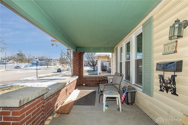 snow covered patio featuring a porch