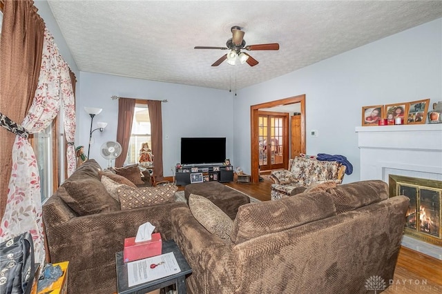 living room featuring ceiling fan, hardwood / wood-style floors, and a textured ceiling