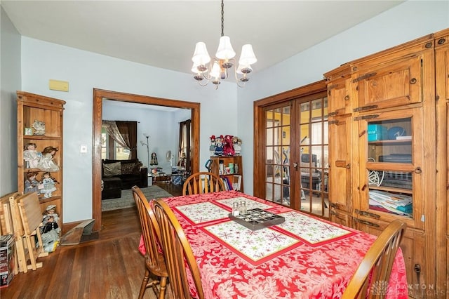 dining room featuring dark hardwood / wood-style flooring, french doors, and a chandelier