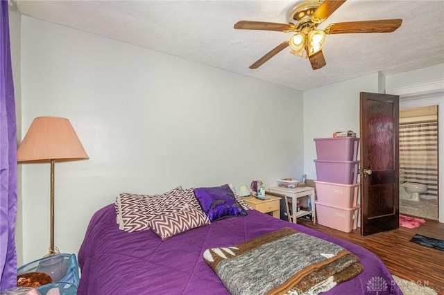 bedroom with hardwood / wood-style flooring, ceiling fan, and a textured ceiling