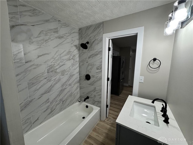 bathroom featuring vanity, tiled shower / bath combo, a textured ceiling, and hardwood / wood-style flooring