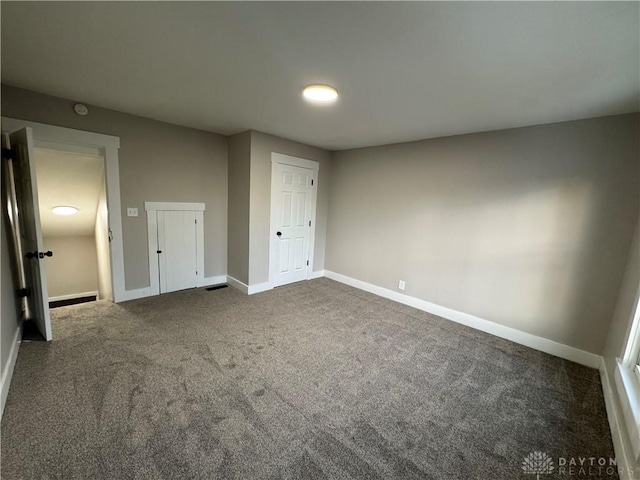 unfurnished bedroom featuring dark carpet